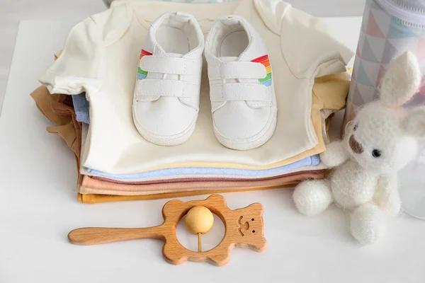 Bebek Kıyafetleri Ayakkabılar Oyuncaklar Beyaz Masada Yakın Plan — Stok fotoğraf