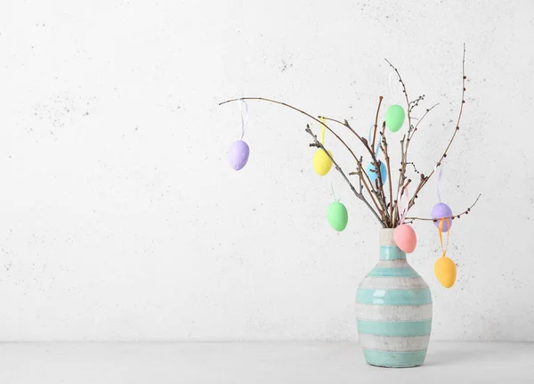 Vase Mit Ästen Und Verschiedenen Ostereiern Auf Hellem Hintergrund — Stockfoto