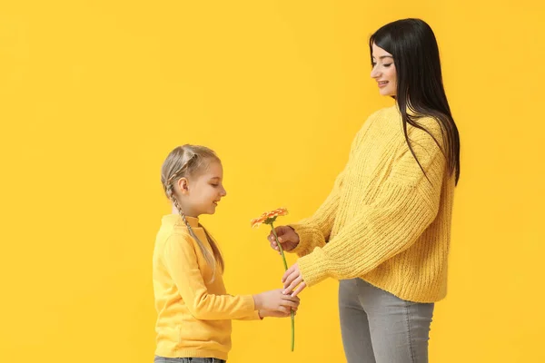 Happy Mother Giving Flower Her Little Daughter Yellow Background — Stock Photo, Image