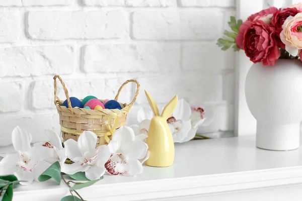 Korb Mit Bemalten Ostereiern Und Blumen Auf Tisch Neben Weißer — Stockfoto