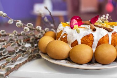 Plate with Easter cake, eggs and pussy willow branches on table, closeup