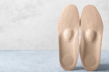 Açık arkaplanda bej ortopedik tabanlar