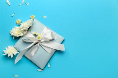 Çiçekli kompozisyon ve Uluslararası Kadınlar Günü için mavi arka planda hediye