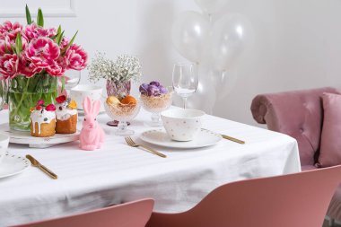 Şık yemek takımı, servis edilen masada Paskalya kekleri ve yumurtalar.