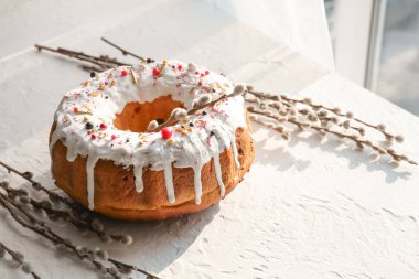 Tasty Easter cake and pussy willow branches on light table