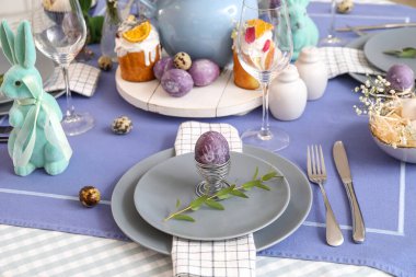 Boyalı Paskalya yumurtası ve okaliptüs dallı tutucu servis masasında.