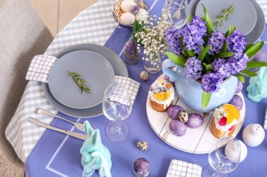 Güzel çiçekler, servis edilen masada paskalya pastaları ve yumurtalar.