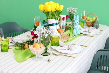 Renk duvarının yanındaki Paskalya kutlaması için şık bir sofra.