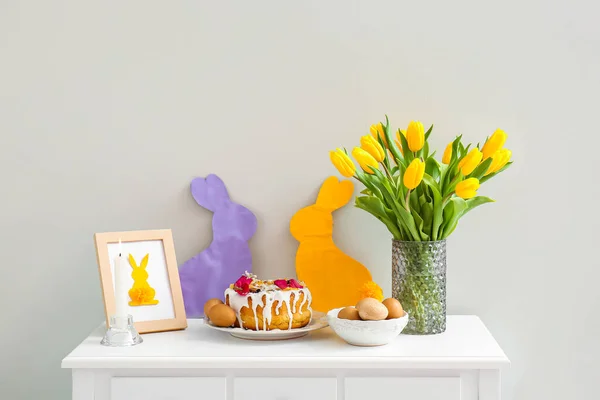 Пасхальный Торт Яйца Тюльпаны Горящая Свеча Декор Столе Светлой Стены — стоковое фото