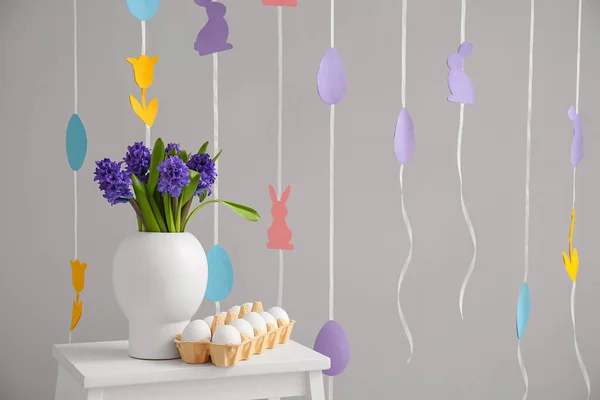 Halter Mit Ostereiern Und Vase Mit Blumen Auf Stufenhocker Nahe — Stockfoto