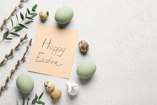 Beautiful Easter composition with greeting card, eggs, pussy willow branches and eucalyptus on light background