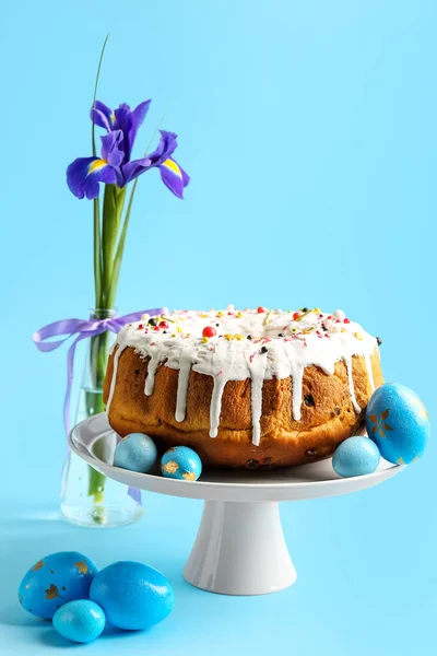 Dessertstandaard Met Lekkere Paastaart Eieren Irisbloem Blauwe Ondergrond — Stockfoto