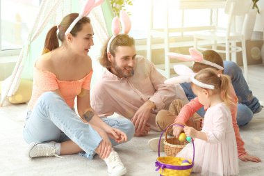 Evde tavşan kulaklı, sepetli ve yumurtalı mutlu bir aile.