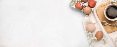 Paskalya yumurtaları ve beyaz zemin üzerinde bir fincan kahve ile kompozisyon.