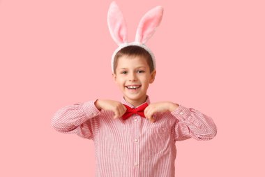 Pembe arka planda tavşan kulaklı komik küçük çocuk.