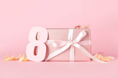 Uluslararası Kadınlar Günü için güzel bir hediye kutusu ve renkli arka planda kağıt figür 8.