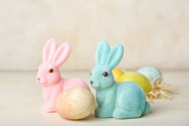 Güzel Paskalya tavşanları ve açık arkaplanda boyanmış yumurta.