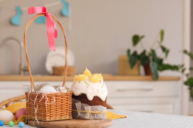 Lezzetli paskalya pastaları, sepet ve yumurtalar mutfaktaki masada.