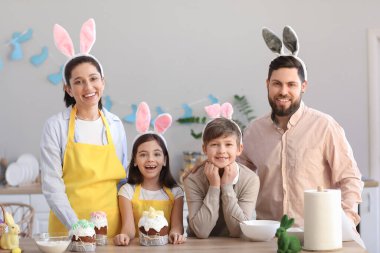 Evde paskalya pastalarıyla tavşan kulaklı mutlu bir aile.