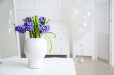 Işık odasındaki masada çiçekli vazo.