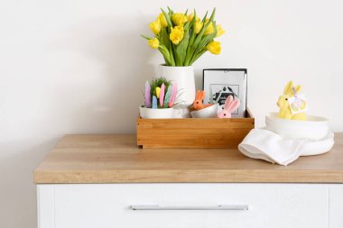 Paskalya dekorlu ahşap kutu ve ışık duvarının yanında güzel laleler.