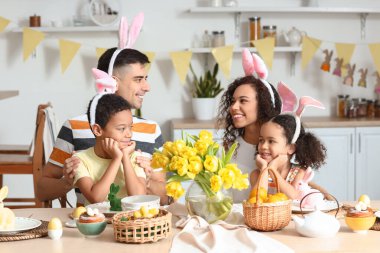 Mutlu aile, Paskalyayı mutfakta yemek masasında kutluyor.