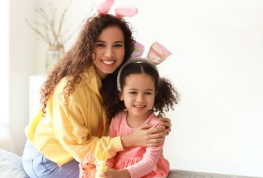 Paskalya tavşanları ve annesi evde olan küçük Afro-Amerikalı kız.