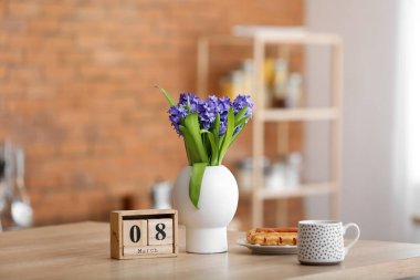 Mutfak tezgahında 8 Mart tarihli vazo, fincan, tatlı ve küp takvimi. Uluslararası Kadınlar Günü kutlamaları