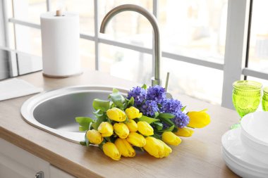 Pencerenin yanındaki modern lavaboda bir buket güzel çiçek