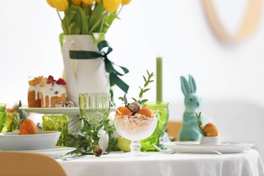 Paskalya yumurtası ve okaliptüs dalıyla servis edilen masada kase.