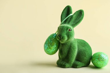 Tatlı Paskalya tavşanı ve bej arka planda yumurtalar.