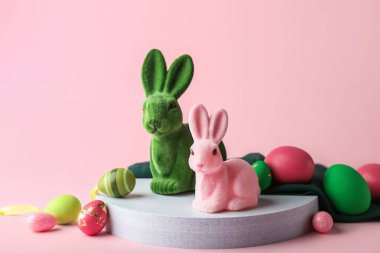 Pembe arka planda boyalı yumurtaları olan şirin Paskalya tavşanları.