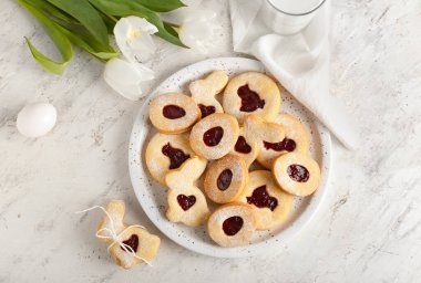 Lezzetli Paskalya kurabiyeleri ve arka planda lale çiçekleri olan tabak.