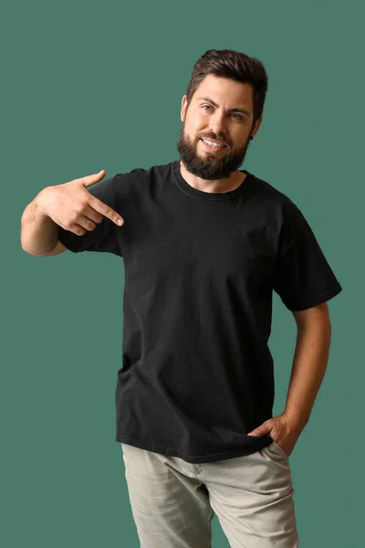 Schöner Mann Zeigt Auf Schwarzes Shirt Auf Grünem Hintergrund — Stockfoto