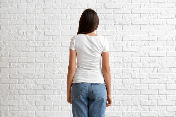 Νεαρή Γυναίκα Λευκό Shirt Λευκό Φόντο Τούβλο Πίσω Όψη — Φωτογραφία Αρχείου
