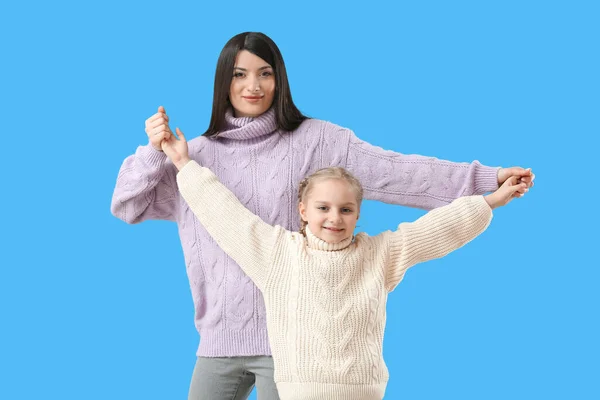 Mała Dziewczynka Jej Matka Ciepłych Swetrach Trzymając Się Ręce Niebieskim — Zdjęcie stockowe