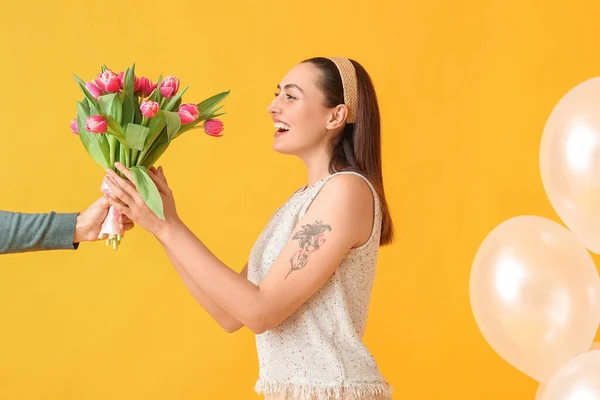 Mujer Joven Feliz Con Ramo Tulipanes Hombre Sobre Fondo Amarillo — Foto de Stock