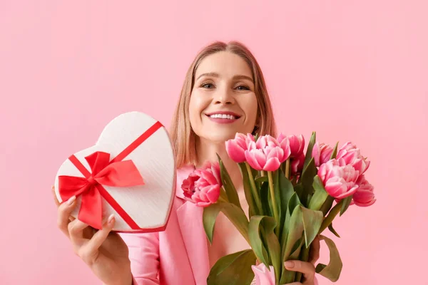 漂亮的女人 带着一束郁金香和粉色背景的礼品盒 国际妇女日 — 图库照片