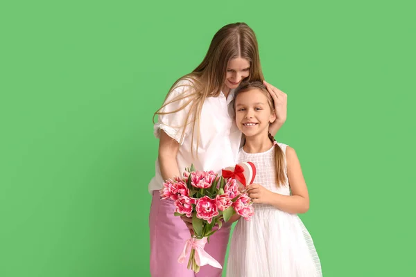 Klein Meisje Met Haar Moeder Geschenken Groene Achtergrond — Stockfoto