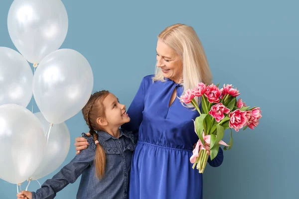 小女孩 她的祖母 背景是蓝色的郁金香和气球 国际妇女日 — 图库照片