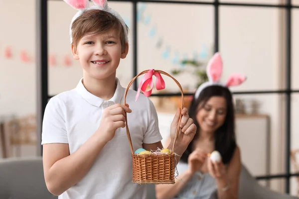 Mały Chłopiec Króliczych Uszach Trzyma Koszyk Jajkami Wielkanocnymi Domu — Zdjęcie stockowe