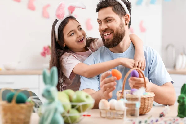 Küçük kız Paskalya günü mutfakta babasına sarılıyor.