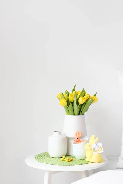 Vaas Met Tulpen Kopjes Paaskonijnen Tafel Bij Lichte Wand — Stockfoto