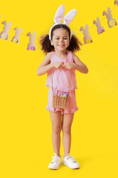 Malá Afroamerická Dívka Namalovanou Tváří Velikonočními Vejci Žlutém Pozadí — Stock fotografie