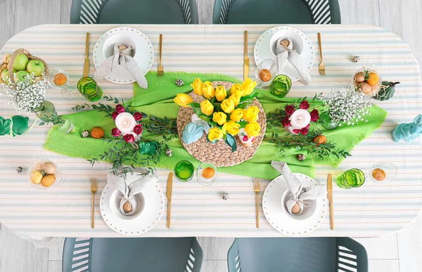 Paskalya kutlaması için masasında güzel çiçekler ve mumlar olan şenlikli bir ortam.