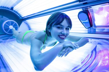 Güneş yatağında güzel genç bir kadın