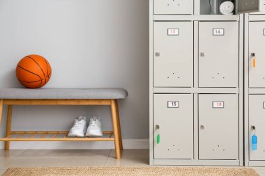 Spor malzemeleri ve soyunma odasında yedek kulübesi olan bir dolap.