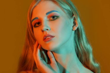 Renkli arka planda sıra dışı kaşları olan güzel bir kız.