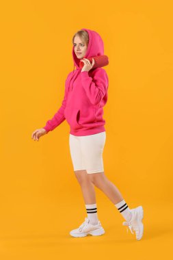 Kablosuz taşınabilir hoparlörü olan kadın renk arkaplanda yürüyor