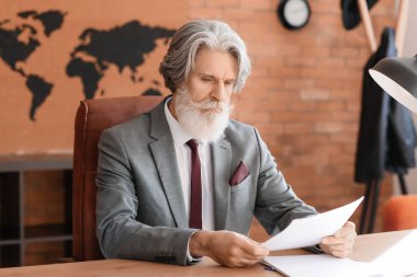 Ofiste çalışan olgun sakallı bir iş adamı.